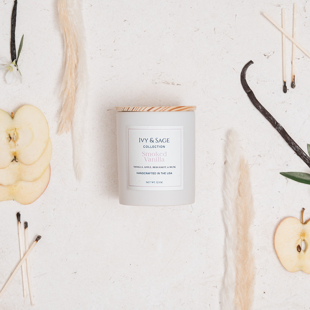 Ivy & Sage Smoked Vanilla ceramic candle flat lay styled with vanilla, apple and neutral natural details.