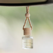 Car air freshener hanging from a car's rearview mirror with a blurred background