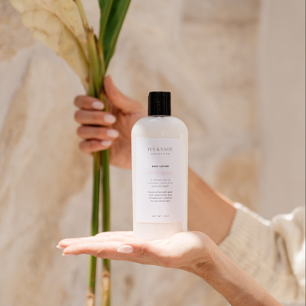 Person holding a bottle of Body Lotion skincare product with a leaf in the background