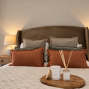 Ivy & Sage White Tea ceramic candle styled with reed diffuser in a warm, cosy bedroom.