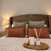 Ivy & Sage ceramic candle styled with home fragrance products in a warm, cosy bedroom.