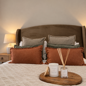 Ivy & Sage Warm Cashmere ceramic candle styled with home fragrance products in a warm, cosy bedroom.
