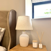 Ivy & Sage reed diffuser styled on a bedside table in a calm, neutral home interior alongside coordinating home fragrance products.