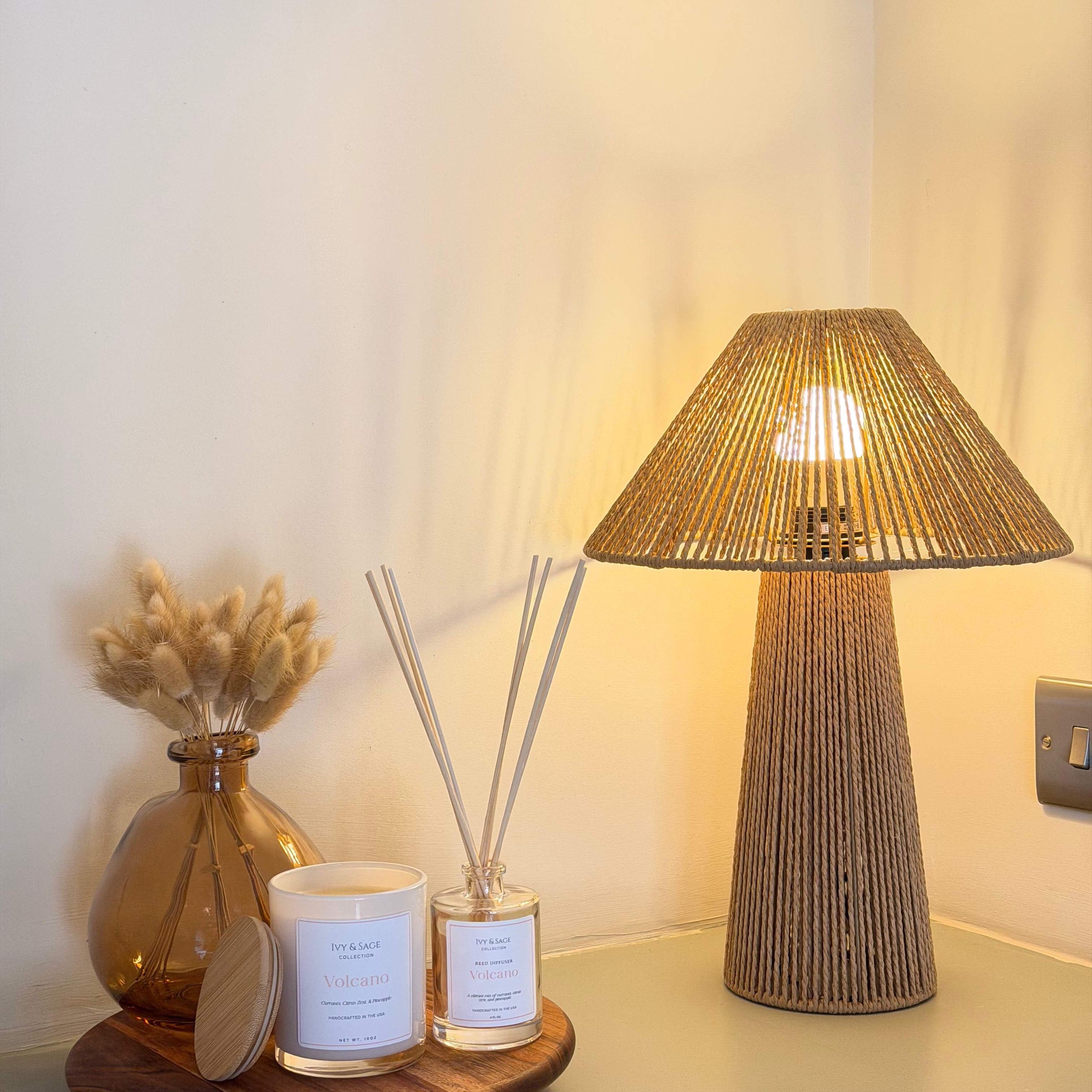 Ivy & Sage reed diffuser styled in a warm, modern home interior alongside coordinating home fragrance products.