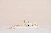 Small glass Car Diffuser bottle on a marble tray against a beige background