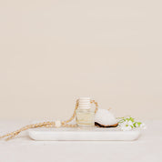 Small glass Car Diffuser bottle on a marble tray against a beige background