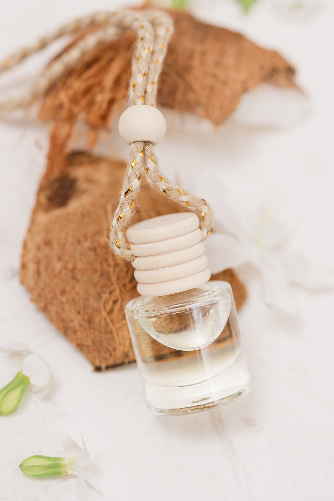 Car Diffuser glass bottle resting on coconut on beige background