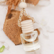 Car Diffuser glass bottle resting on coconut on beige background