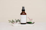 Room & Linen Spray on a white surface with decorative elements in Warm Cashmere scent