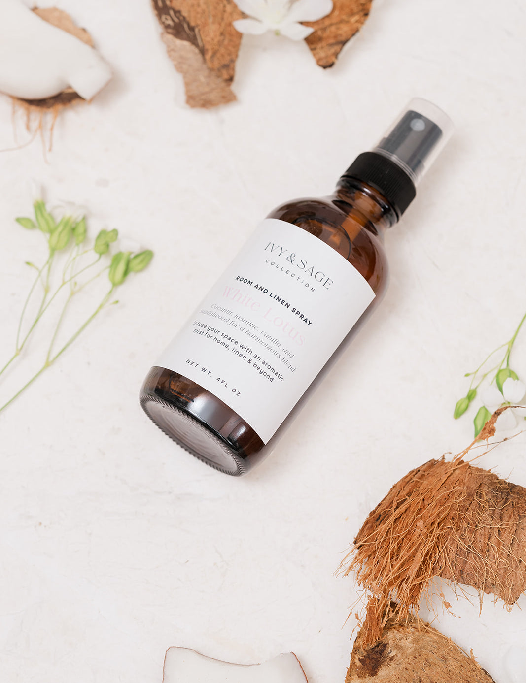 Room & Linen spray bottle with a label on a white surface with coconuts and flowers.
