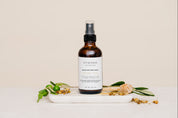 Room & Linen Spray with honey and white tea on white marble slab