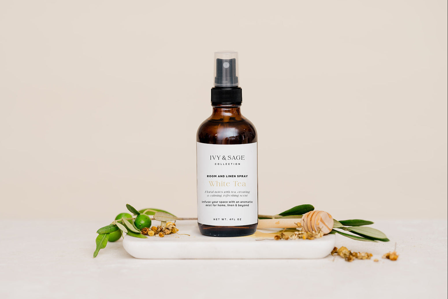Room & Linen Spray with honey and white tea on white marble slab