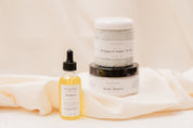 IVY & SAGE skincare products including a body oil, sugar scrub and body butter on a beige background