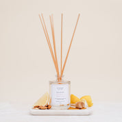 Ivy & Sage Honey & Almond reed diffuser with natural reeds, styled with lemon, honey and almonds on a neutral background.