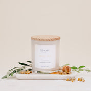 Ivy & Sage White Tea glass candle with wooden lid, styled with delicate botanicals and natural details.