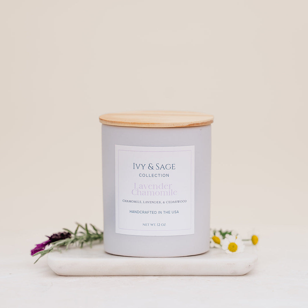 Ivy & Sage Lavender & Chamomile ceramic candle with wooden lid, styled with lavender and chamomile flowers.