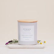 Ivy & Sage Lavender & Chamomile ceramic candle with wooden lid, styled with lavender and chamomile flowers.
