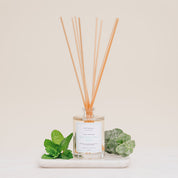 Ivy & Sage Eucalyptus Mint reed diffuser with natural reeds, styled with fresh mint and eucalyptus leaves on a neutral background.