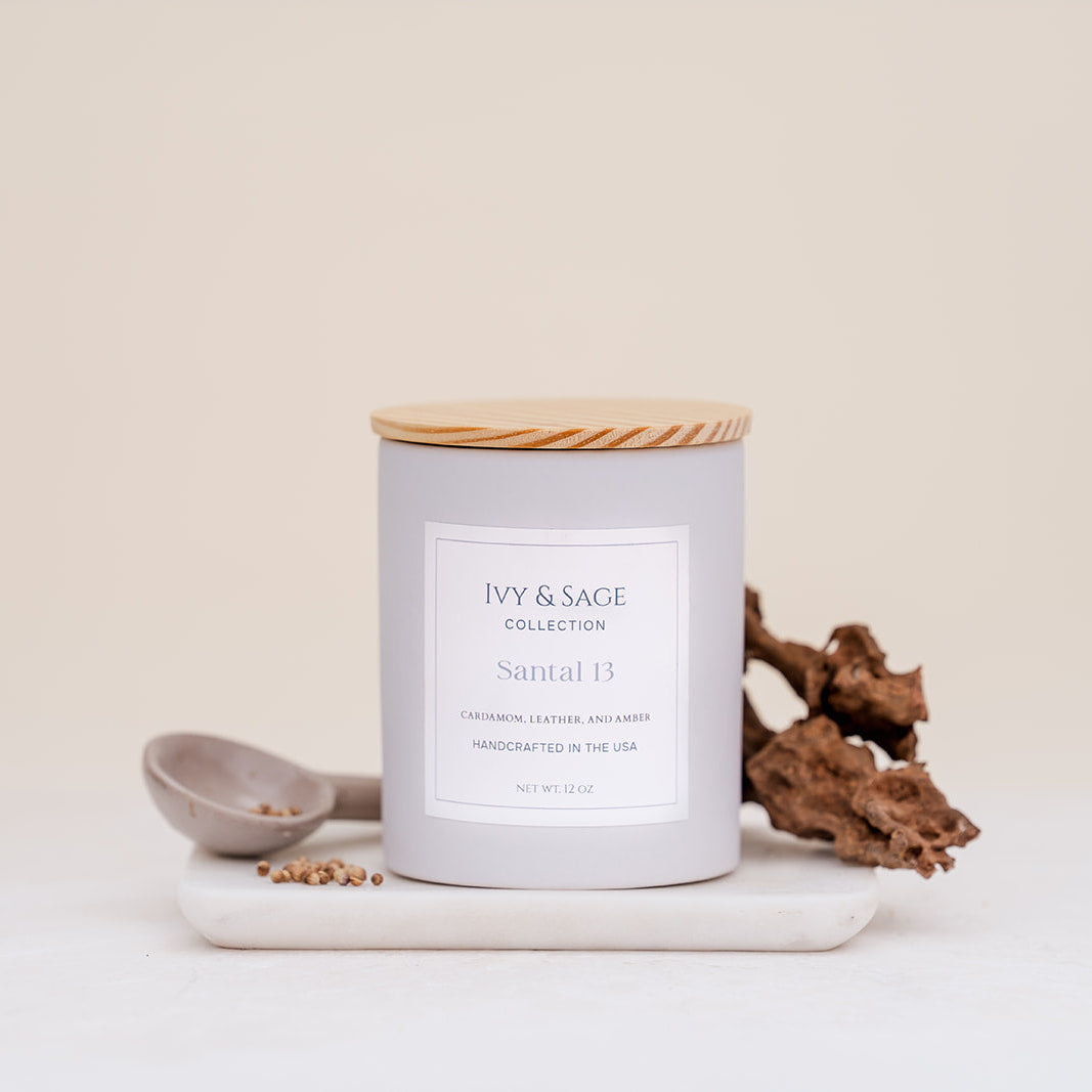 Ivy & Sage Santal 13 ceramic candle with wooden lid, styled with warm woody and natural details.