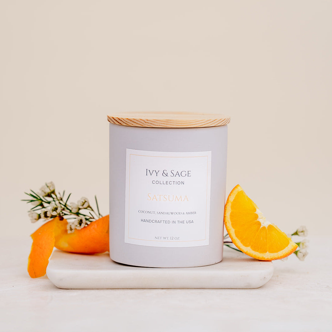Ivy & Sage Satsuma ceramic candle with wooden lid, styled with fresh orange and citrus details