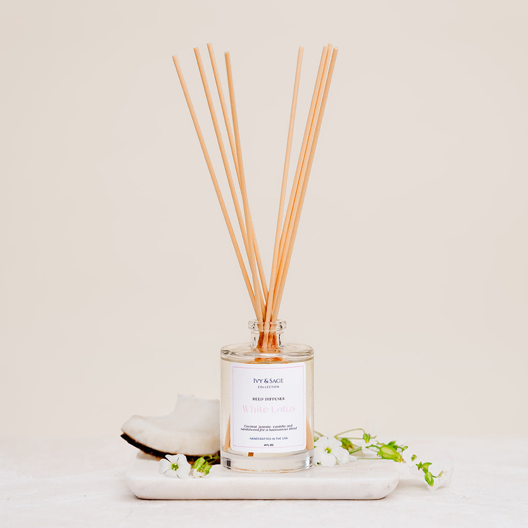 Ivy & Sage White Lotus reed diffuser with natural reeds, styled with delicate white florals on a neutral background.