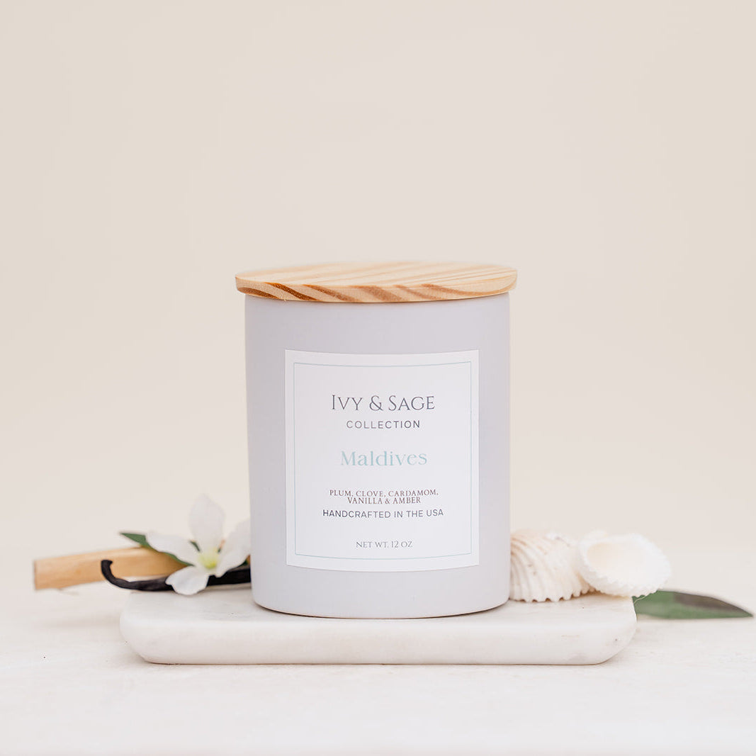 Ivy & Sage Maldives ceramic candle with wooden lid, styled with soft coastal-inspired details.