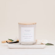 Ivy & Sage Maldives glass candle with wooden lid, styled with natural coastal-inspired details.