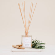 Ivy & Sage Palo Santo reed diffuser with natural reeds, styled with palo santo wood and greenery.