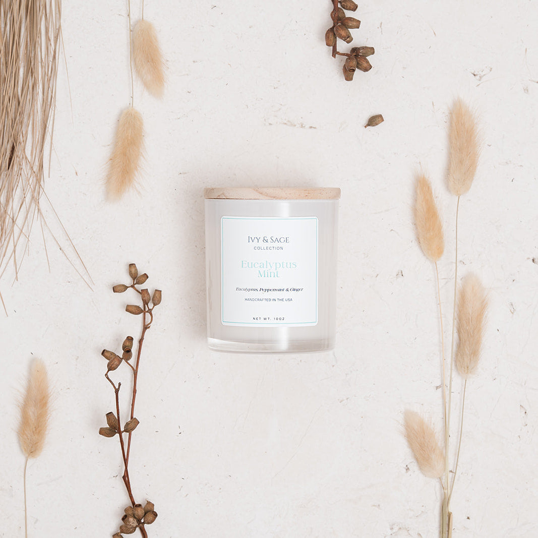 Ivy & Sage Eucalyptus Mint glass candle flat lay styled with soft neutral botanicals.