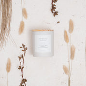 Ivy & Sage Warm Cashmere ceramic candle styled in a neutral botanical flat lay.