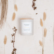 Ivy & Sage Satsuma ceramic candle flat lay styled with soft neutral botanicals and natural details.