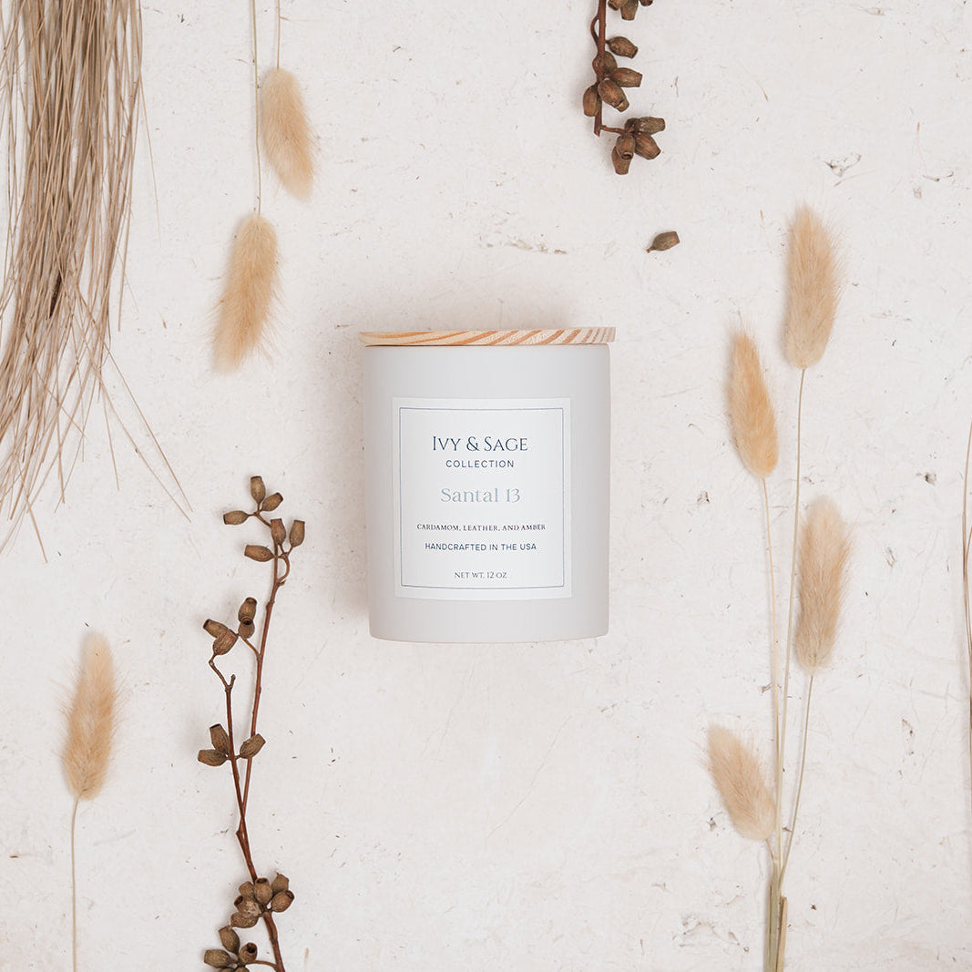 Ivy & Sage Santal 13 ceramic candle flat lay styled with neutral botanical and woody details.