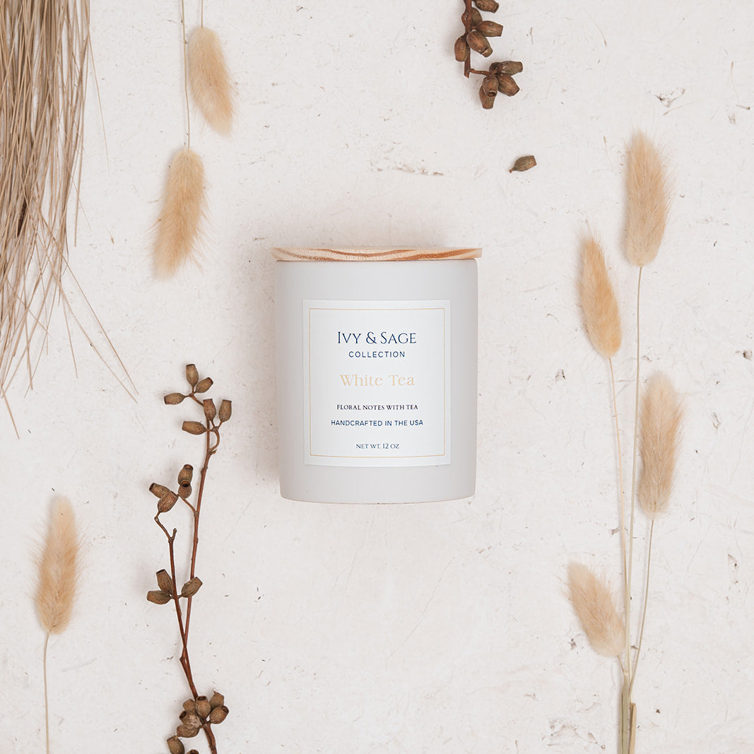 Ivy & Sage White Tea ceramic candle flat lay styled with soft neutral botanicals and natural details.