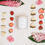 Ivy & Sage Volcano ceramic candle flat lay surrounded by pineapple, strawberries and tropical flowers.
