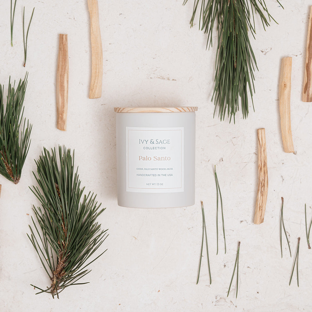 Ivy & Sage Palo Santo ceramic candle flat lay styled with palo santo wood and botanical greenery.